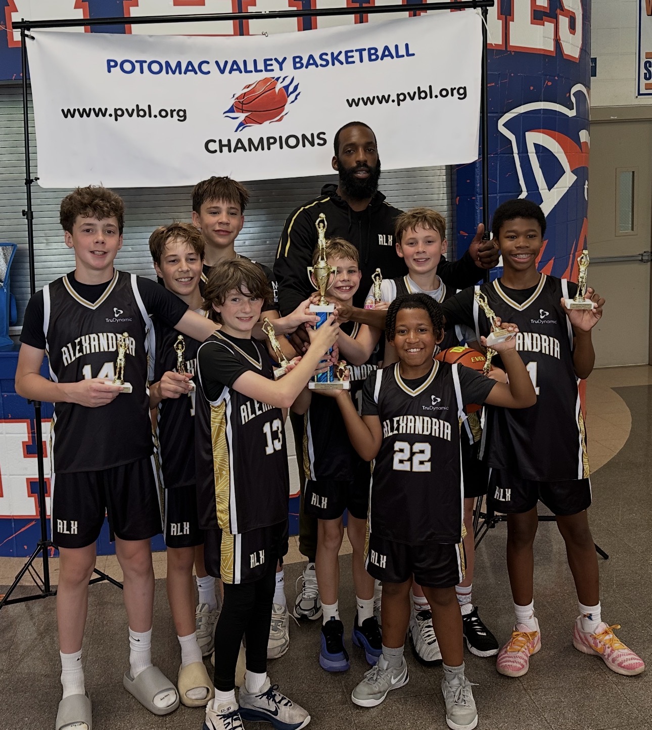 ALX Basketball players and Coach Lucky Jones celebrating the Potomac Valley Tournament championship